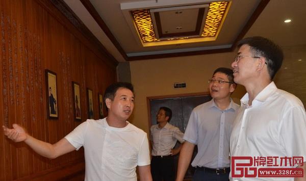 旭东红木董事长李晓东(左一)为金华市委书记陈龙(右一)等介绍旭东红木