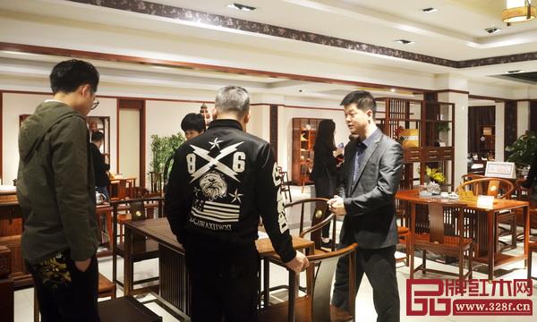 水雨轩企业代表宋献政(右一)向经销商介绍功夫茶台 水雨轩企业代表宋献政(右一)向经销商介绍功夫茶台