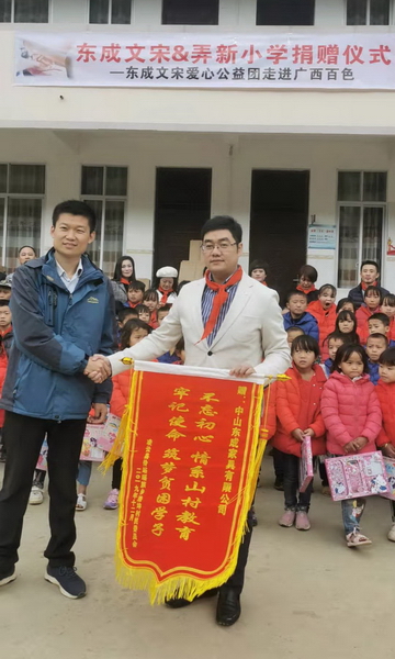 凌云县浩坤村驻村书记刘栋明（左）为东成红木赠送锦旗