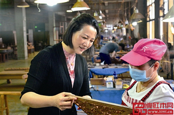 金品世家总经理、技术总监林丽钗（左）在工厂与工人交流产品工艺