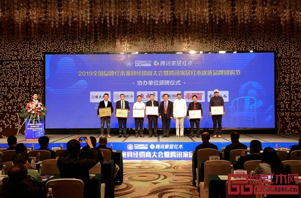 2019全国品牌红木家具经销商大会暨腾讯家居红木优选品牌团购节协办单位颁牌,水雨轩董事长廖升中(左三)上台领牌 2019全国品牌红木家具经销商大会暨腾讯家居红木优选品牌团购节协办单位颁牌,水雨轩董事长廖升中(左三)上台领牌