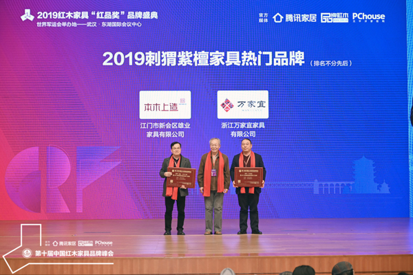 雄业·本木上造摘得“2019刺猬紫檀家具热门品牌”,董事长钟超雄(左一)上台领奖,中央民族大学人体工程学专家苏垣(中)为其颁奖 雄业·本木上造摘得“2019刺猬紫檀家具热门品牌”,董事长钟超雄(左一)上台领奖,中央民族大学人体工程学专家苏垣(中)为其颁奖