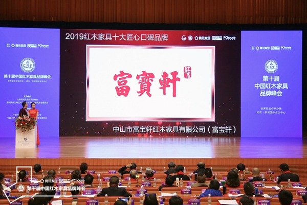 红木品牌峰会现场，正播放富宝轩红木荣获“2019红木家具十大匠心口碑品牌”的颁奖视频