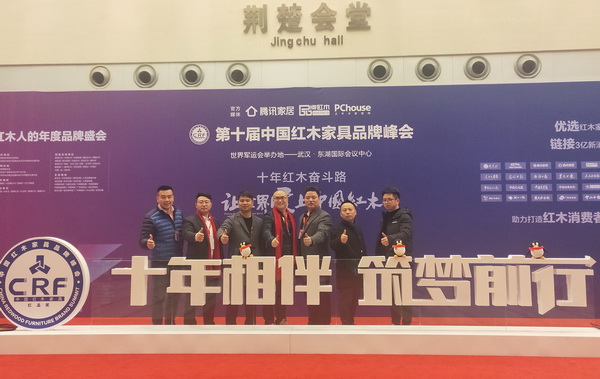 沽之大匠营销总监胡欣（左一）与众多东阳青年企业家在第十届中国红木家具品牌峰会现场合影