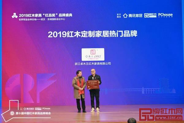 红星美凯龙集团高级顾问吴为为（左）为“2019红木定制家居热门品牌”颁奖