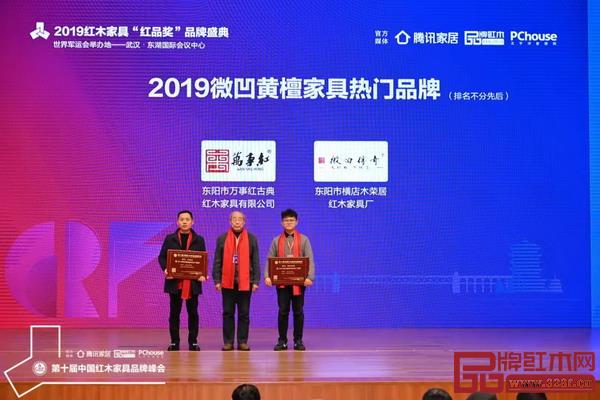 中国红木家具技术专家曹新民（中）为“2019微凹黄檀家具热门品牌”颁奖