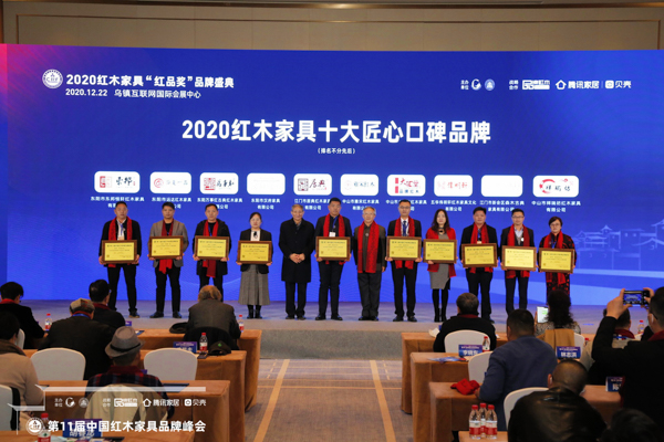 居典紅木榮獲“2020紅木家具十大匠心口碑品牌，全聯(lián)民間文物藝術(shù)品商會(huì)副會(huì)長、全聯(lián)藝術(shù)紅木家具專業(yè)委員會(huì)顧問、故宮博物院文保科技部原主任曹靜樓（左五）、全聯(lián)藝術(shù)紅木家具專業(yè)委員會(huì)專家顧問、華南農(nóng)業(yè)大學(xué)博士生導(dǎo)師李凱夫（右六）為其董事長尹付林（左六）頒獎(jiǎng)