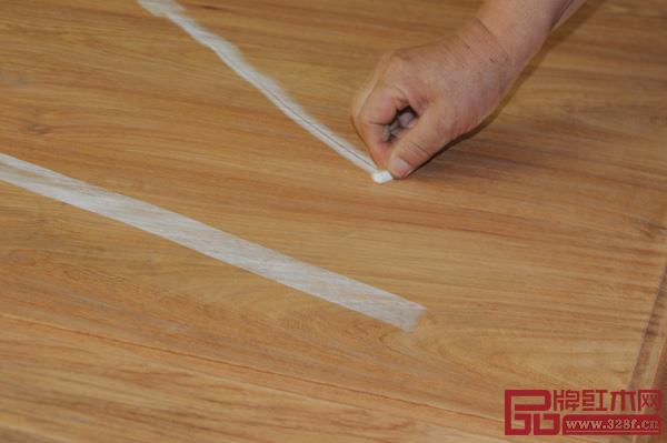 中信红木工匠用粉笔检测刮磨平整度