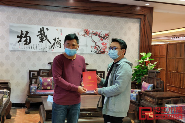 中国红木消费权益保障工程（广东）副主任邓钦昌（左）为居典红木消费者叶先生（右）颁发“红木家具产权证”，并在购买的家具前合照