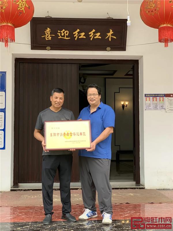 东阳市消费者协会秘书长韦响亮与喜迎红红木董事长陆飞跃(左一)合影留念 东阳市消费者协会秘书长韦响亮与喜迎红红木董事长陆飞跃(左一)合影留念