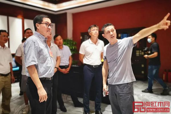 中国家具协会副理事长、红古轩品牌创始人吴赤宇（右一）为中山市人大常委会副主任关瑞麟（左三）、中山市人大常委会委员、教科文卫外侨工委主任邝伟东（右二）介绍红古轩企业概况