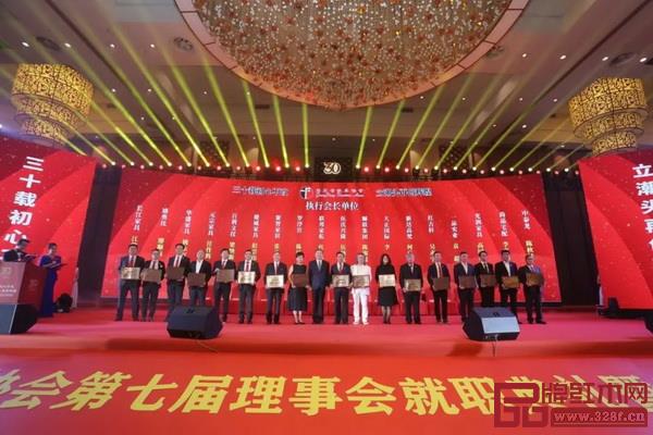 中国家具协会理事长徐祥楠(左九)为广东省家具协会执行会长颁牌,红古轩品牌创始人吴赤宇(右四)上台接受颁牌 中国家具协会理事长徐祥楠(左九)为广东省家具协会执行会长颁牌,红古轩品牌创始人吴赤宇(右四)上台接受颁牌