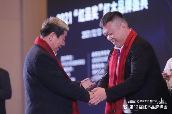 国家文物局原副局长张柏（左）为富雅红木楼董事长杨少辉（右）颁发风云企业家奖杯