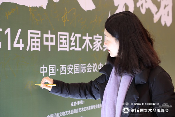 红古轩营销总监杨晶在第14届中国红木家具品牌峰会现场签到留影