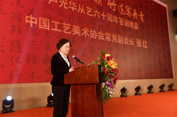 ▲中国工艺美术协会常务副会长张红宣读贺信