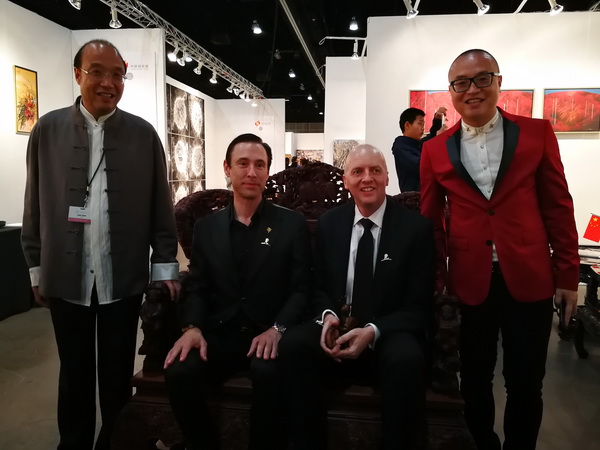卓木王作品跟随文化部去美国洛杉矶参加文化交流，洛杉矶艺博会董事局主席斯科特（左二）、洛杉矶艺博会艺术总监KIM（右二）试坐《中国梦和谐宝座》，并与中国传统工艺大师、卓木王董事长杜承三（左一），卓木王总裁杜长江（右一）合影留念